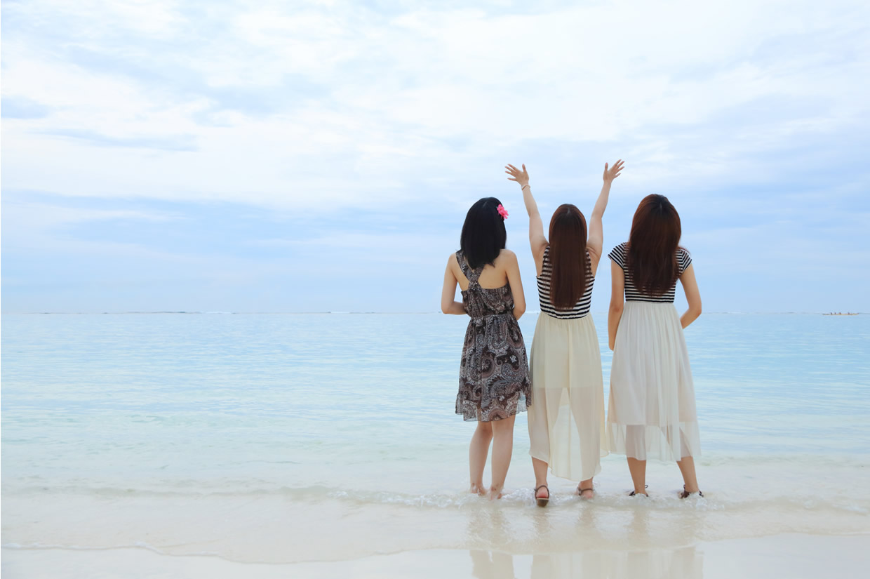 女性３人組がビーチの前でたたずむ写真